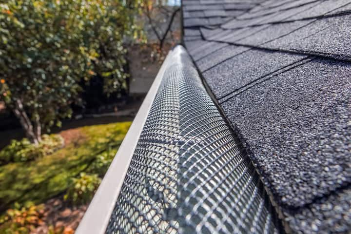 A contractor demonstrating the effectiveness of a gutter guard to a potential client in Syracuse